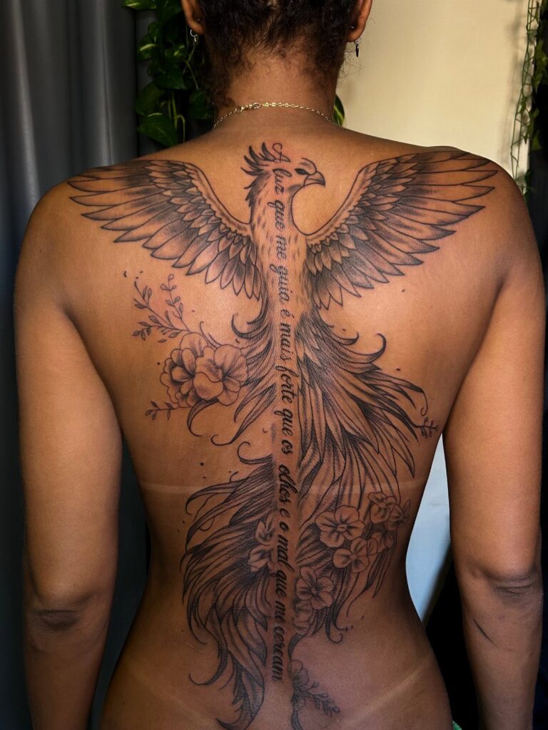 Phoenix tattoo with outstretched wings and flowers covering a person's entire back.