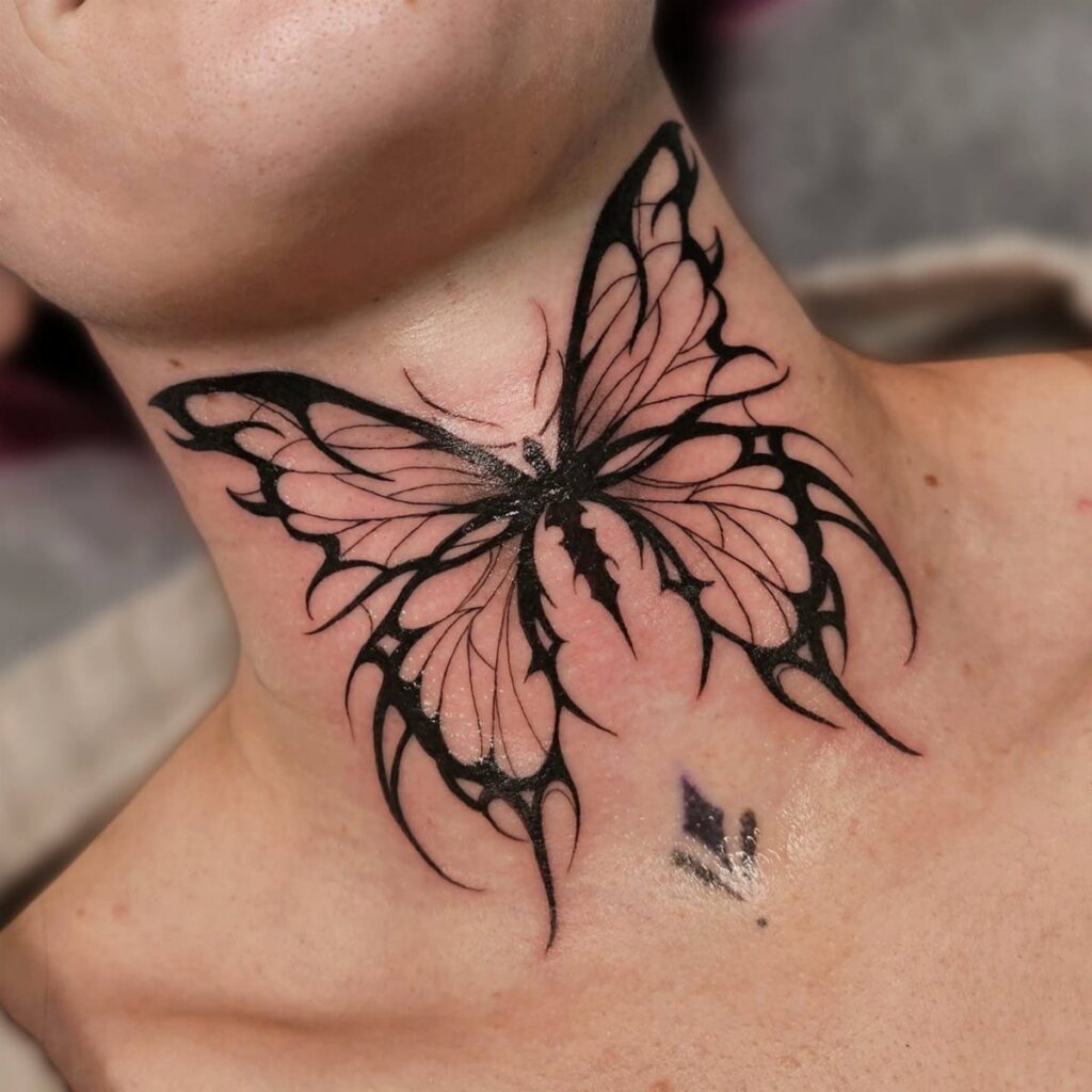 Stylized black butterfly tattoo centered on a person's neck with sharp wing details.