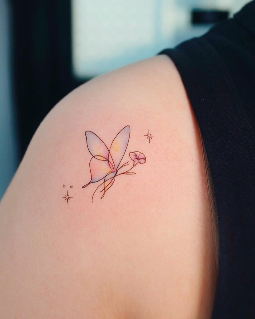 Watercolor butterfly tattoo with pink and yellow wings and a small flower.