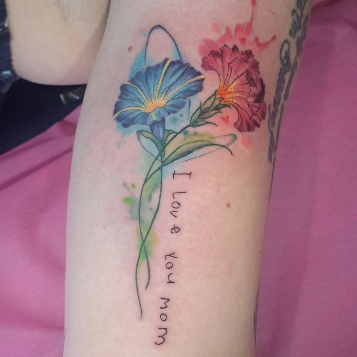 Watercolor tattoo of blue and red flowers with the text I love you mom