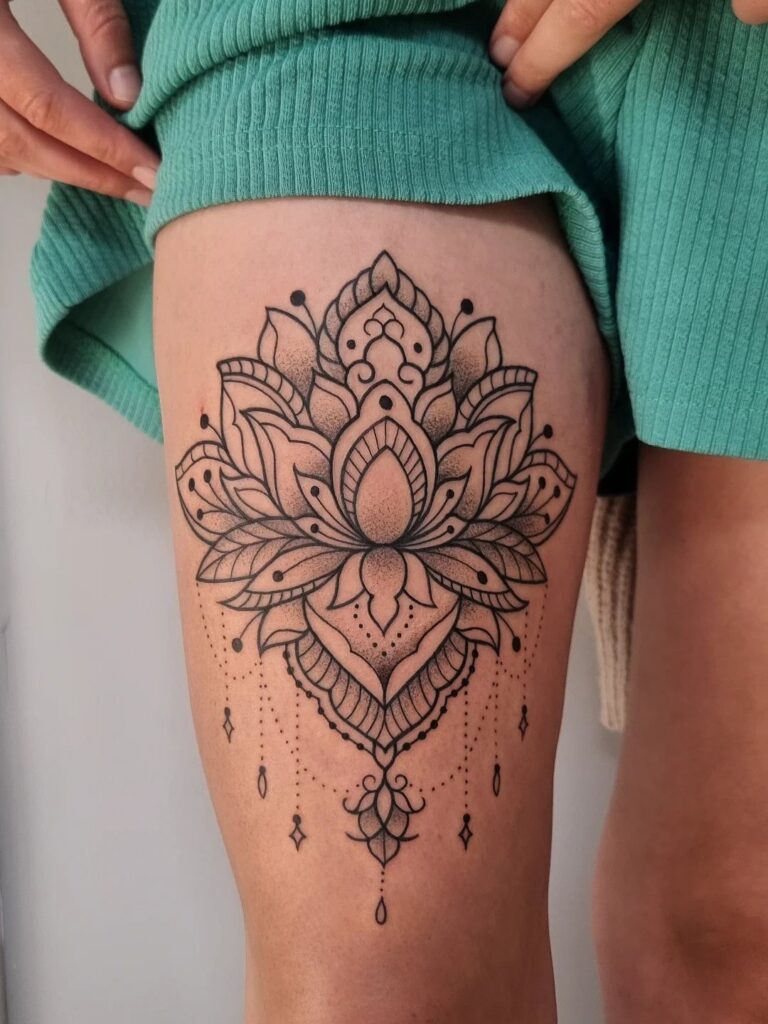 Lotus mandala tattoo with intricate dotwork and geometric lines on a person's thigh