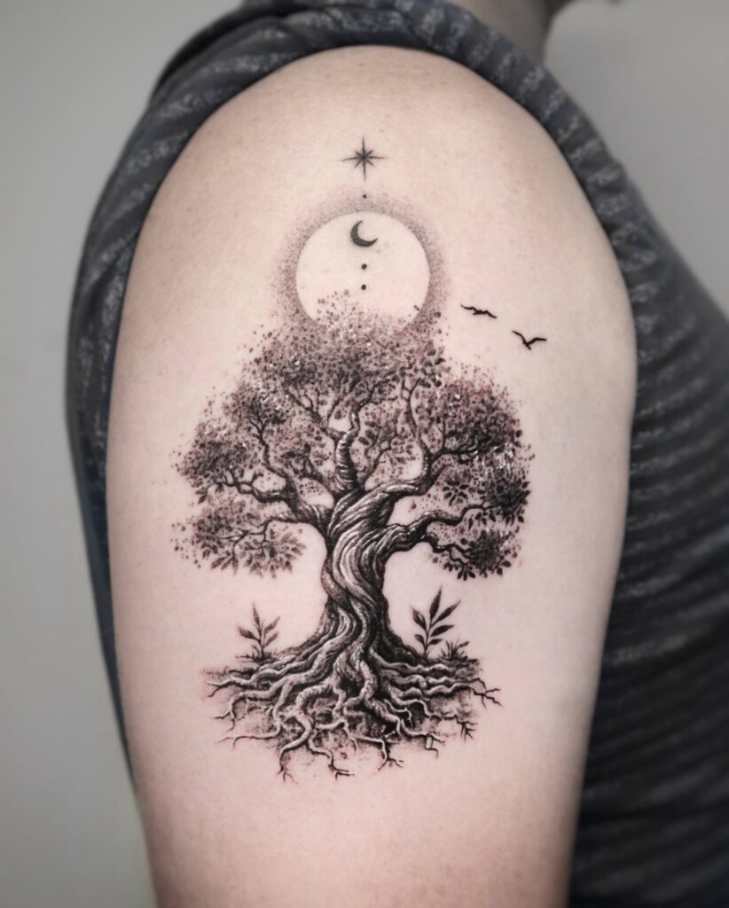 Tree of life tattoo on an upper arm with moon and star details.